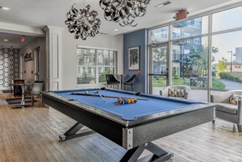 a pool table in a living room with a large window